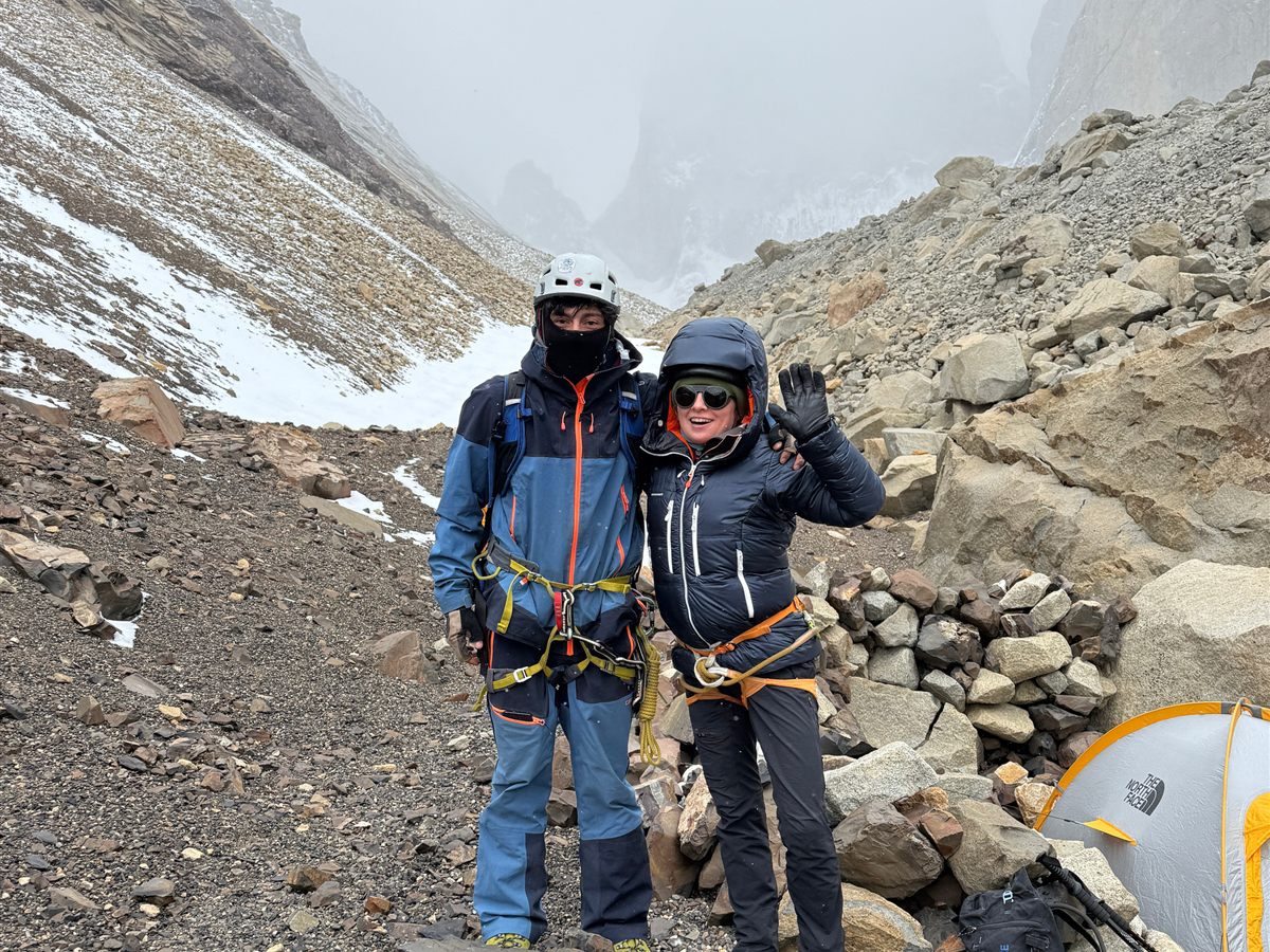 Guía y clienta en el campamento base bajo la Torre Norte en día de niebla