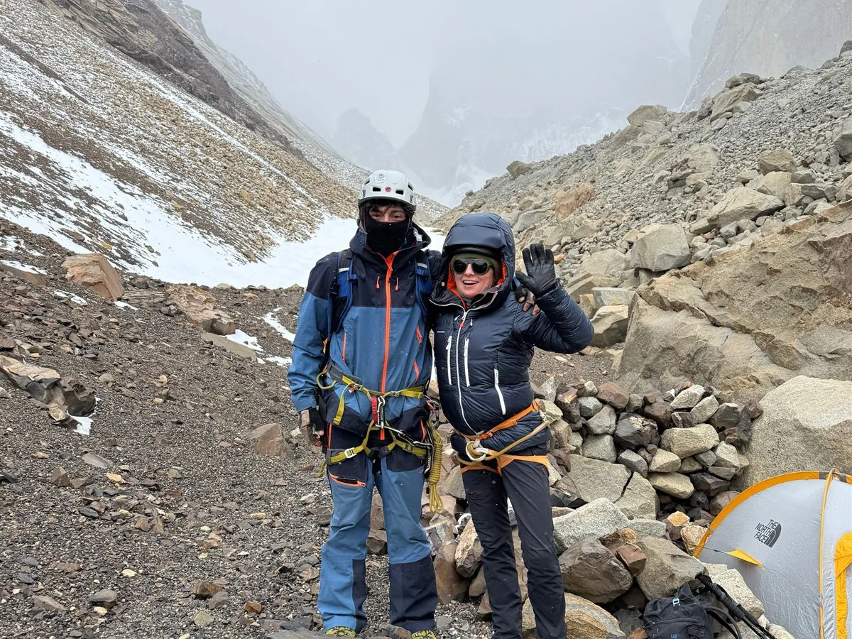 Guía y clienta en el campamento base bajo la Torre Norte en día de niebla