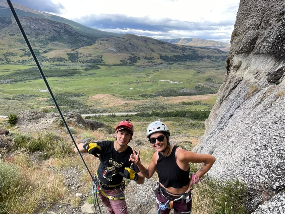 Cordada celebrando al pie de la pared con el valle verde de fondo, Patagonia