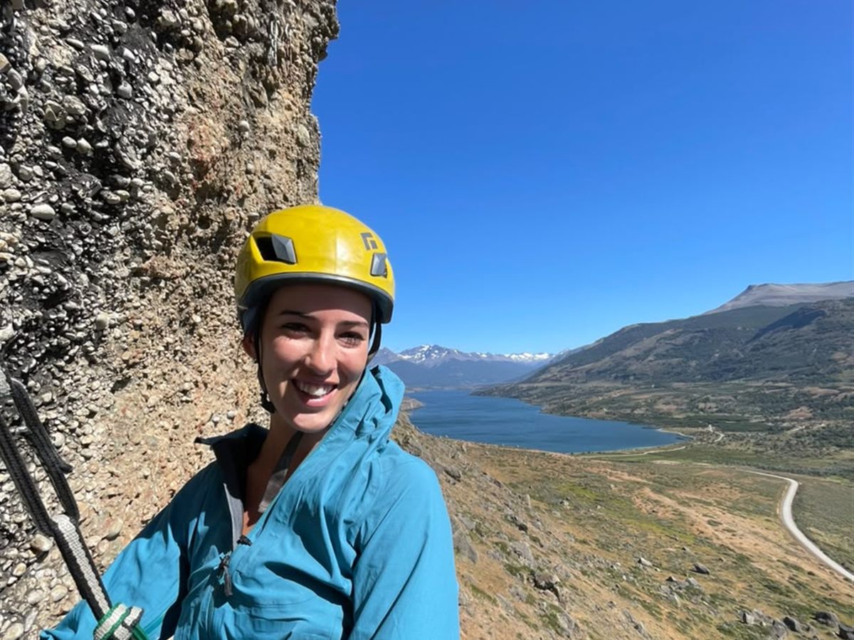Escaladora en la repisa de reunión con vista al lago y la cordillera, Laguna Sofía